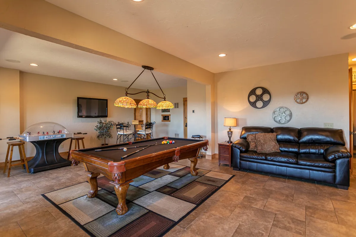 This image captures a vibrant game room featuring a pool table, comfortable sofa seating, and stylish lighting fixtures. The setup invites friendly competition and socializing, perfectly reflecting the recreational spirit highlighted in the section.